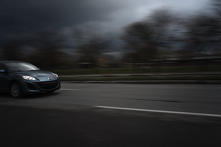 selective focus photography of silver Mazda 3 crossing road at daytime