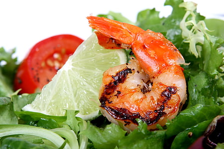 closeup photo of vegetable salad with shrimp and lemon on top