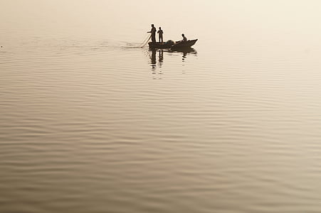 three men on the boat in the middle of the lake