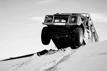 grayscale photography of vehicle on desert during daytime