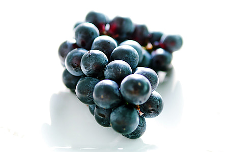 black grapes on white surface