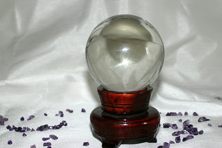 round clear glass ball decor with purple stone on white satin