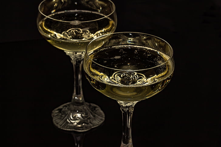 two clear cocktail glasses on black surface close-up photo