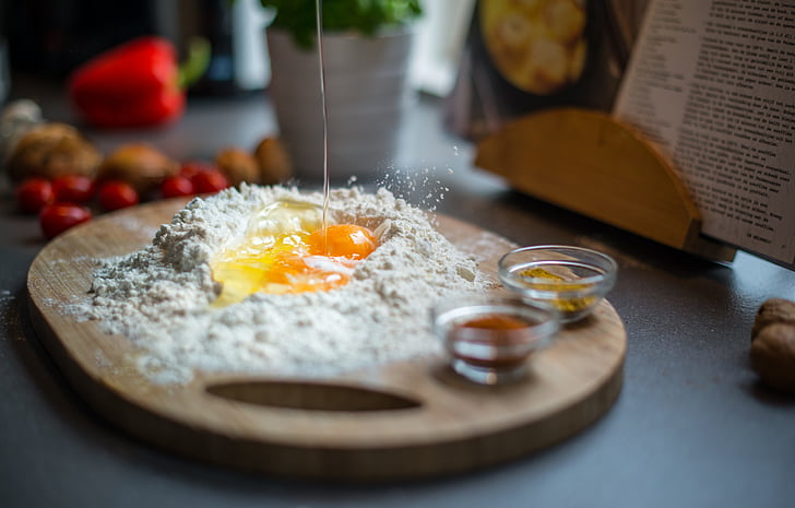 selective focus photography of raw egg surrounded by flour