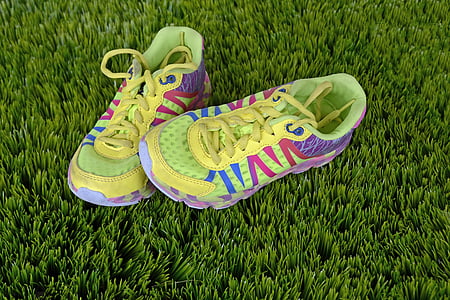 yellow-blue-pink-and-purple sneakers over green grass