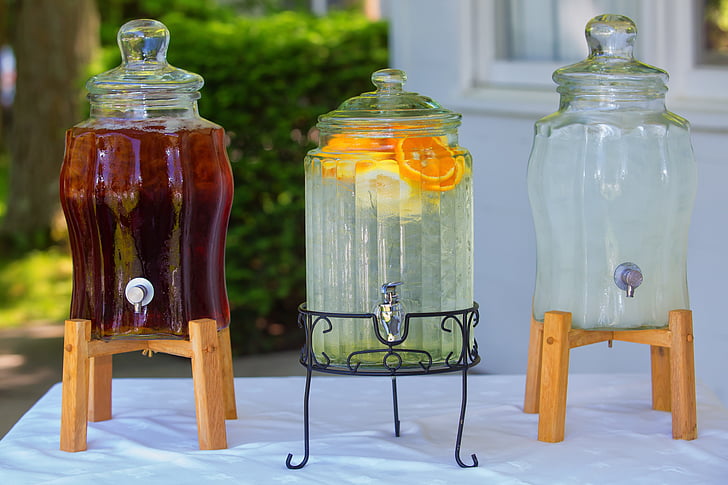 three clear beverage dispensers on top of table