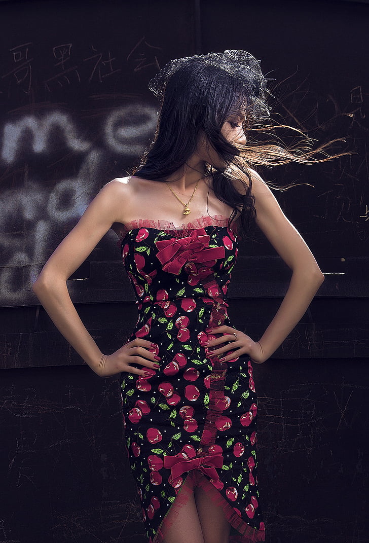 woman wearing red and black floral dress holding waists