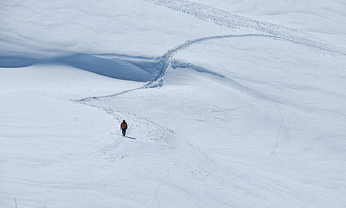 person walks on snow covered mountain