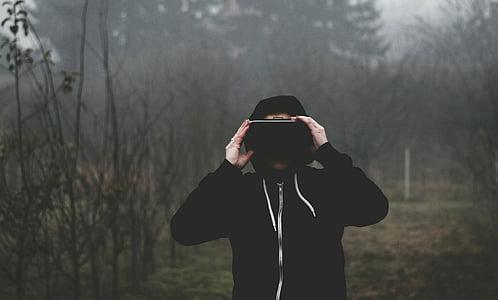 man wearing black zip-up hoodie holds VR box