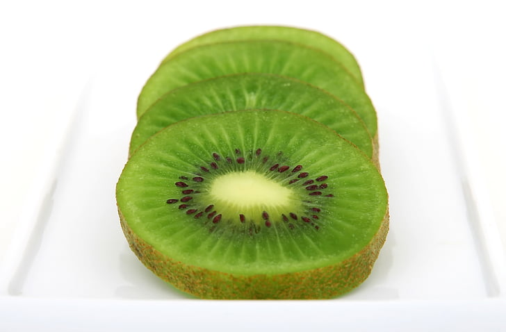 sliced kiwi fruit on white surface