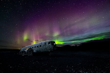 photo of airplane under northern lights