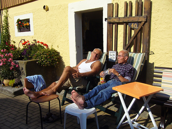 two men sitting on lounge outdoor