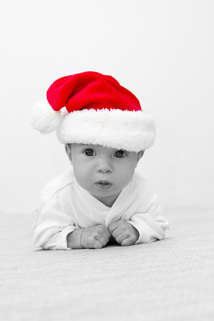 gray scale photo of baby wearing Santa hat