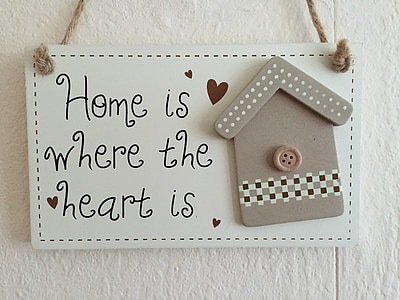 white and gray wooden signage with Home is where the heart is text