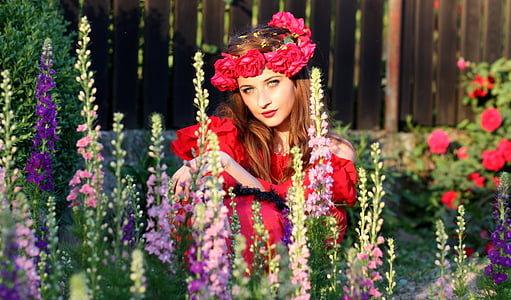 women wearing red off-shoulder shirt holding flowers
