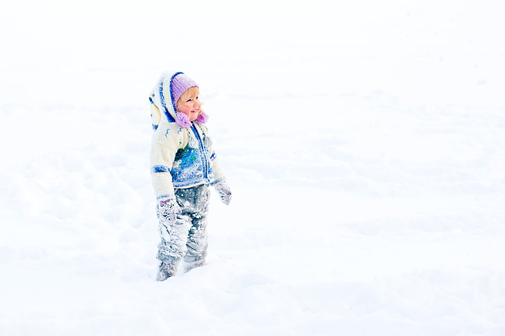 toddler girl standing on snow covered ground