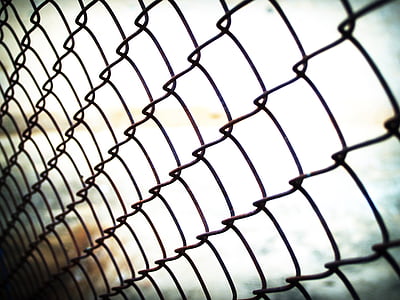 bokeh photography of black cyclone fence