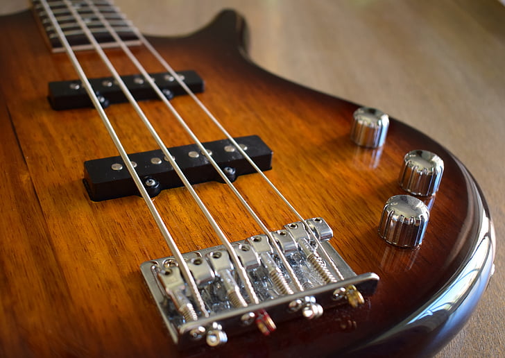 shallow focus photography of brown 4-stringed electric bass guitar
