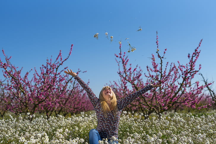 selective focus photography of woman in the middle of white flower field