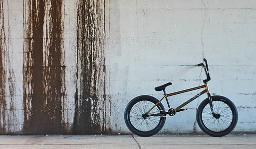 black BMX bike near grey wall