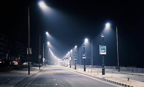 roadside parking lot with streetlamps during nighttime