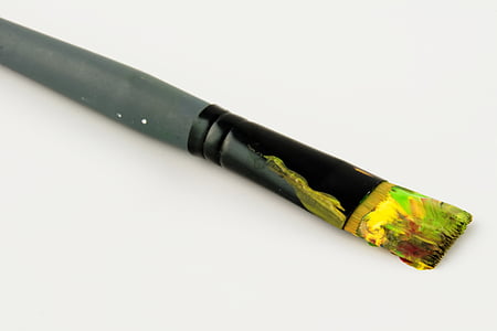 grey paintbrush with yellow and green paint