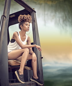 tilt-shift lens photography of woman in white tank top sitting in cab