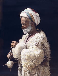 man wearing white fur coat painting