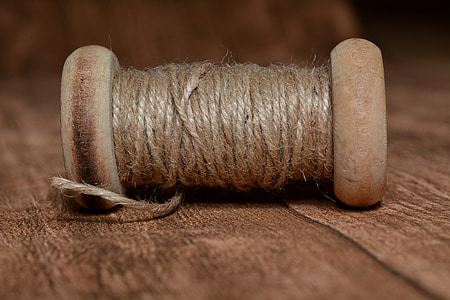 brown thread spool in closeup photography