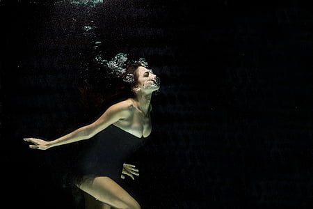 woman wearing black strapless dress underwater