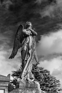 gray angel statue under cloudy sky
