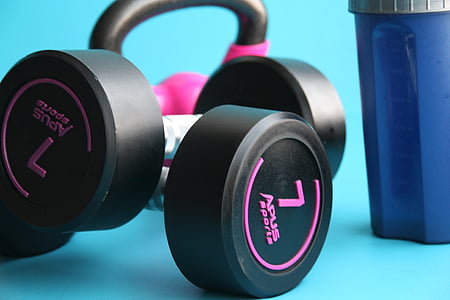 selective focus photography of black and pink Apus Sports fixed-weight dumbbells