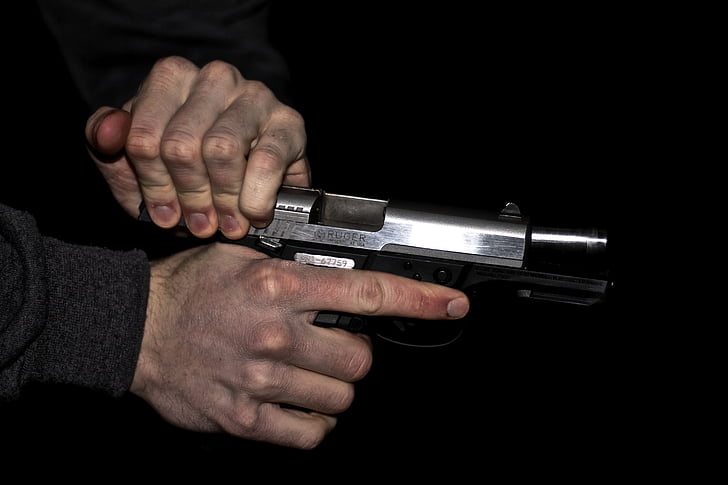 person holding gray semi-automatic pistol