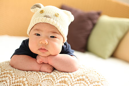 baby wearing white knit cap on focus photo