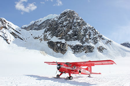 closeup photo of red airplane near mountain