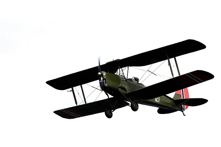 brown biplane flying through the sky