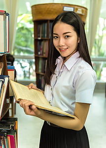 woman in whiteblouse and black shirt holding book