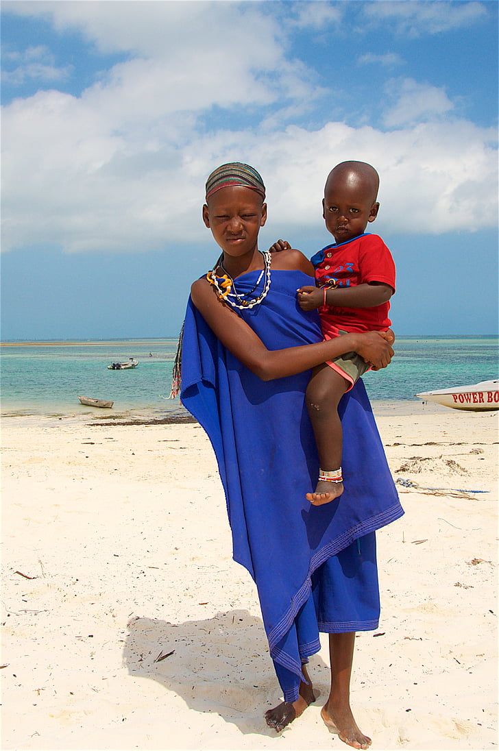 woman carrying a baby near seashore