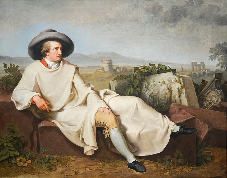 man wearing white top sitting on brown concrete brick painting