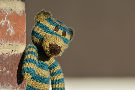 close-up photography of brown and blue striped bear amigurumi toy