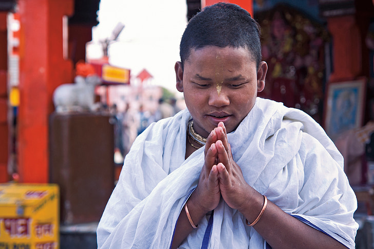 man wearing white scarf while praying during daytime