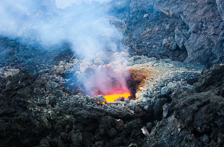 volcano lava surrounded with rock during daytime