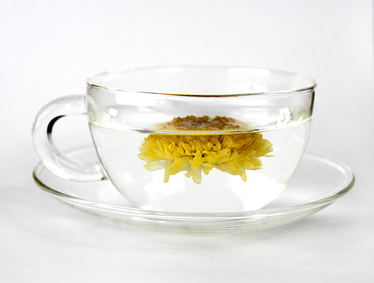 clear glass teacup with saucer