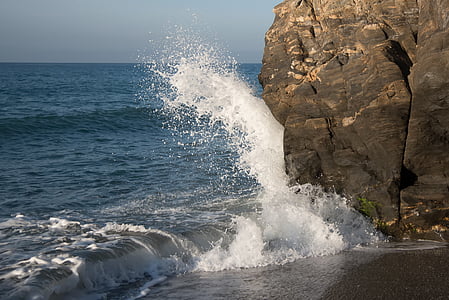 seawaves smashing through rock formation
