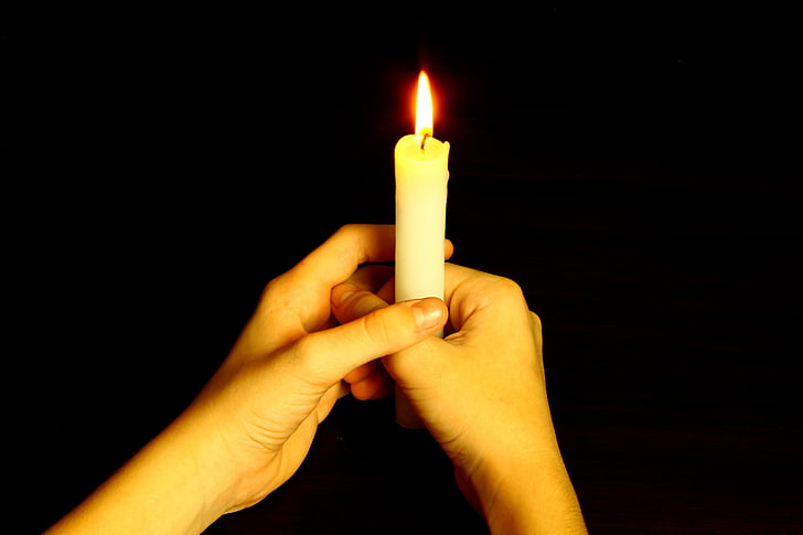 person holding white candle