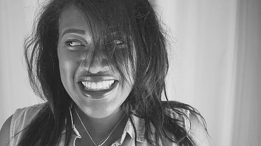 woman smiling in grayscale photography