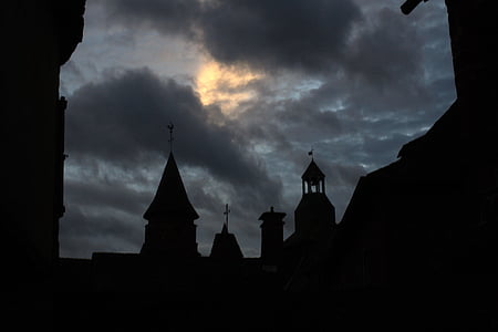 silhouette of church under cloudy sky