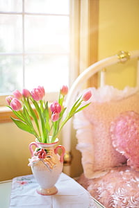 pink tulip flowers with green leaf on white and pink ceramic vase