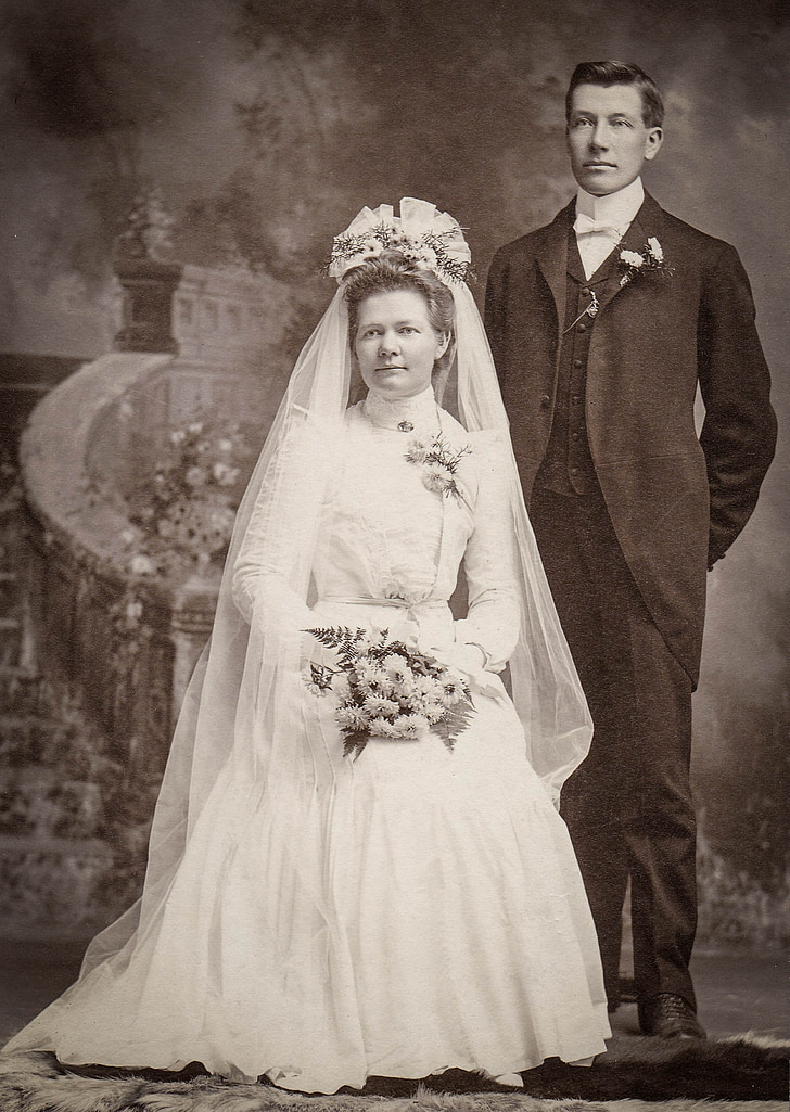 woman wearing wedding gown beside man wearing suit