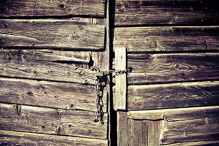 brown wooden door with chains